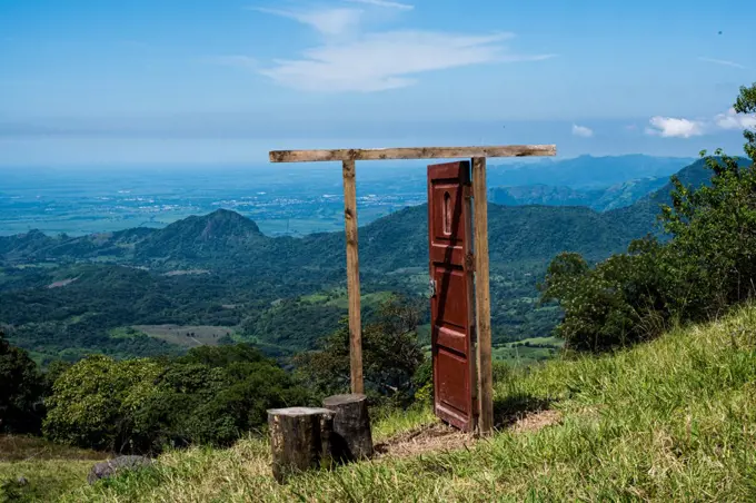 open door in the middle of a meadow