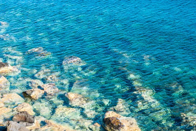 Turquoise sea water and large stones at the bottom of the sea