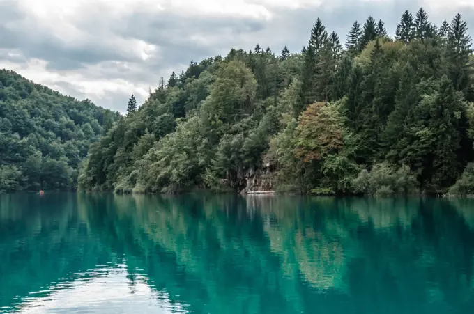 Lonely boat in the Plitvice Lakes of Croatia in cloudy day.