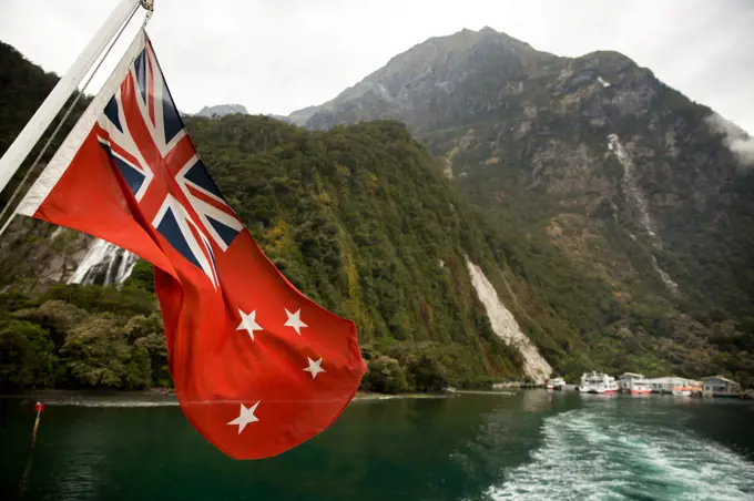 New Zealand Flag waving in Milford Sound in New Zealand