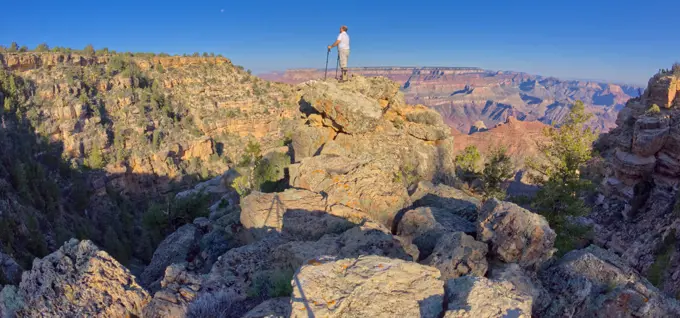 Hiker climbing boulders at Grand Canyon AZ