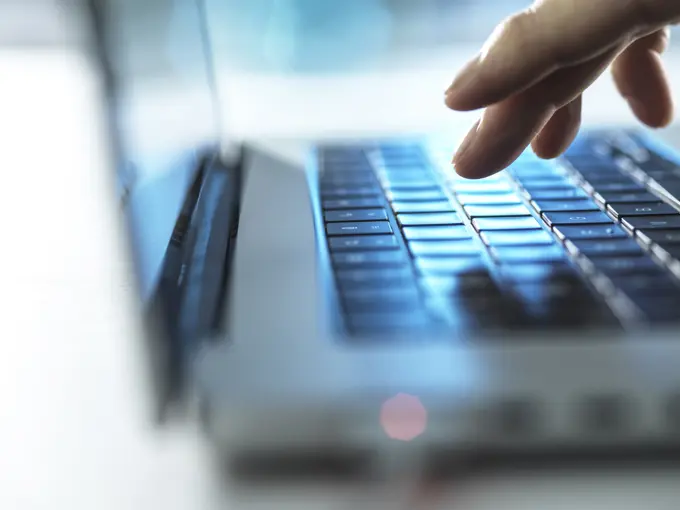 Online Working, Man typing on laptop computer in office