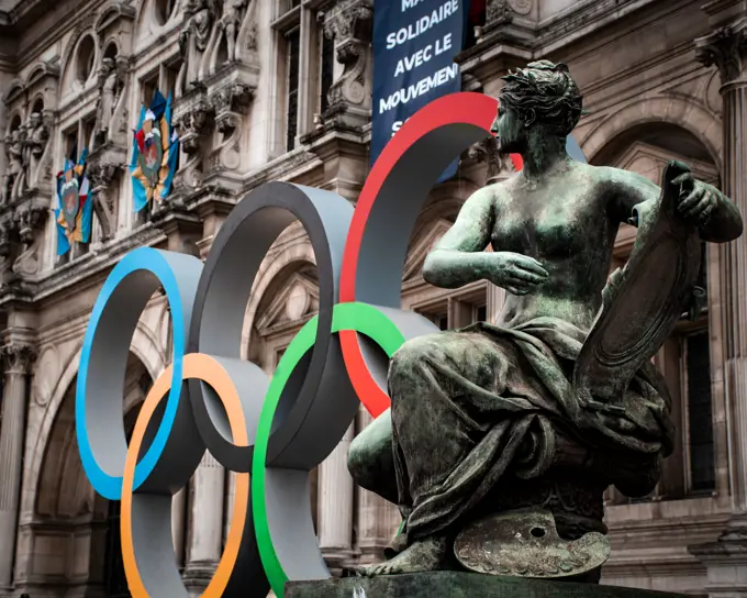 woman statue in front of paris city hall with olympic rings