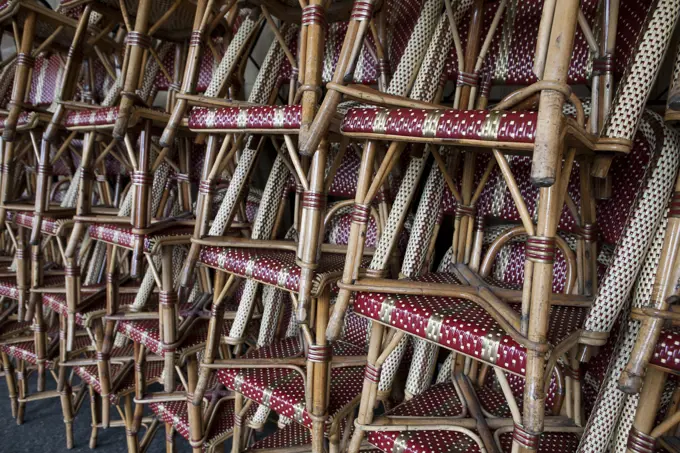 Cafe chairs stacked on a sidewalk in Paris, France.