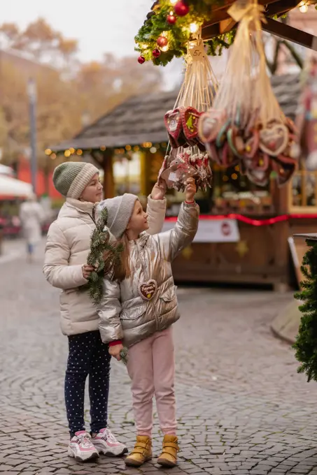 Two girls walk at the Christmas market in Germany, gingerbread