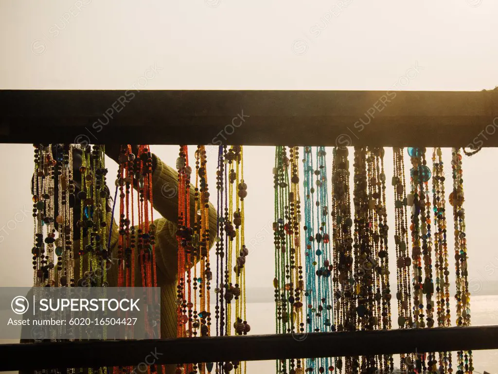 Woman hanging beaded jewelry, Varanasi, India