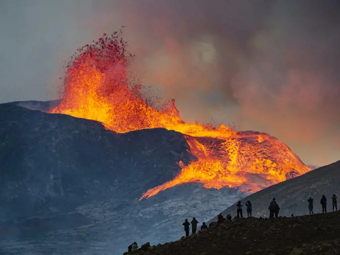 Hikers enjoy fireworks from Observation Hill as glowing lava is ejected from Fagradalsfjall Volcano, Iceland