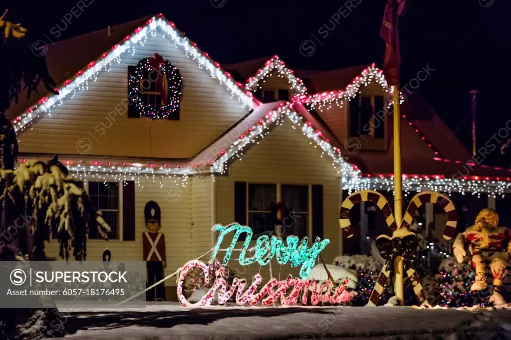 Decorated house for Christmas at night covered in snow