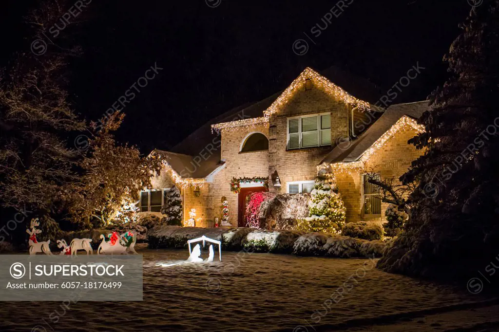 Decorated house for Christmas at night covered in snow