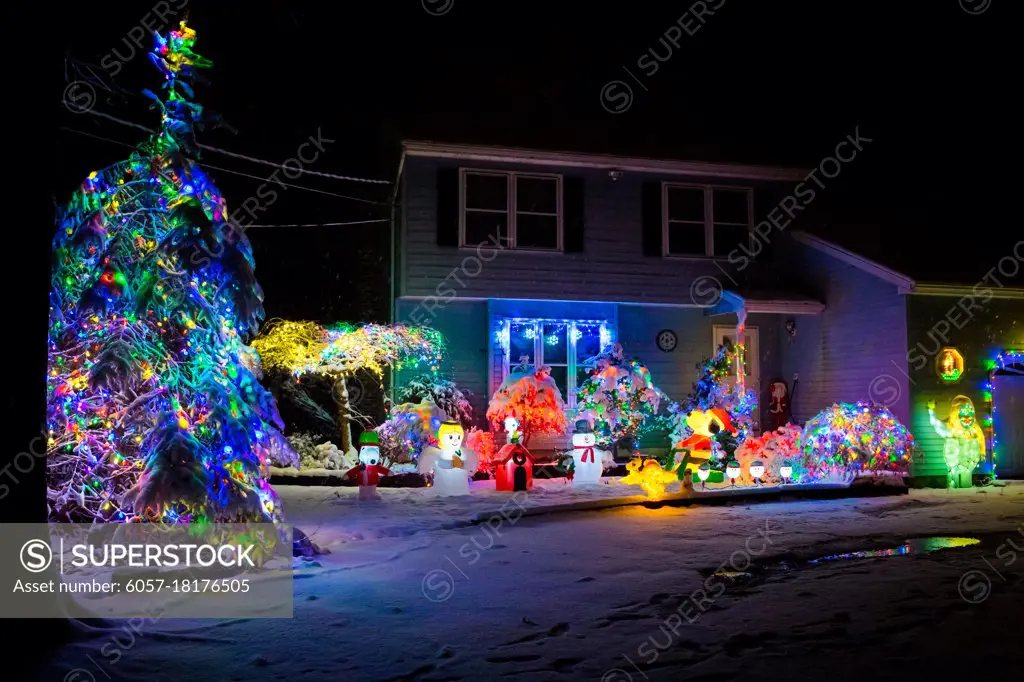 Decorated house for Christmas at night covered in snow