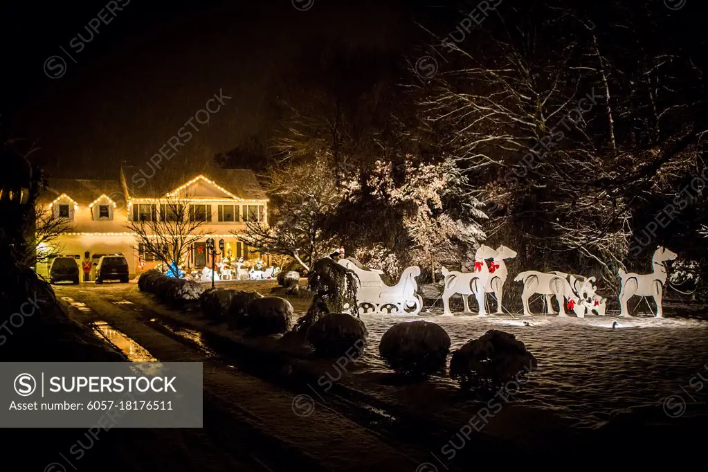 Decorated house for Christmas at night covered in snow