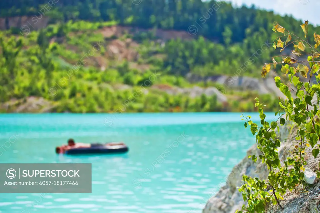 Swimming on a mattress in a beautiful place blurred