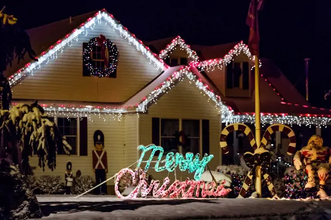 Decorated house for Christmas at night covered in snow