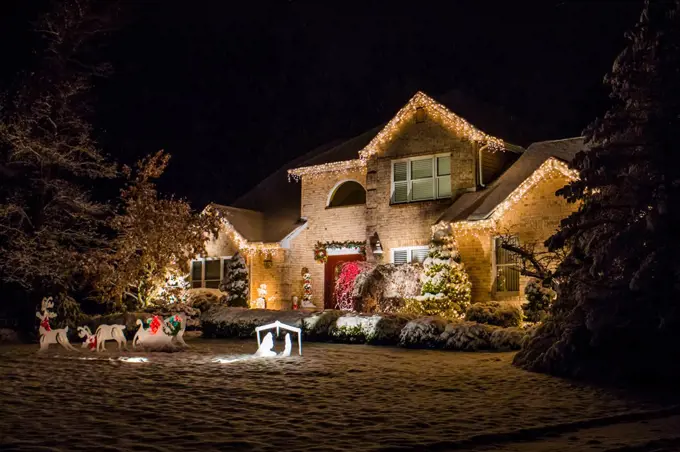 Decorated house for Christmas at night covered in snow