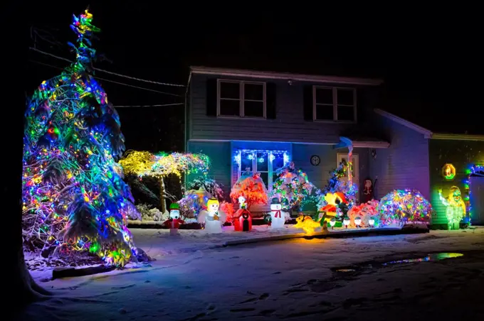 Decorated house for Christmas at night covered in snow