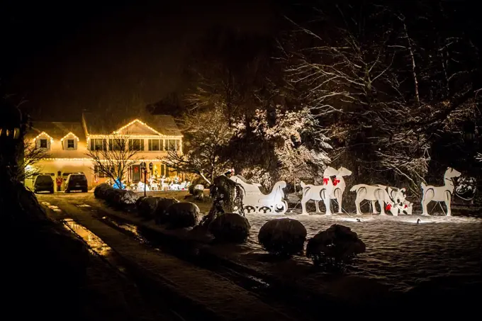 Decorated house for Christmas at night covered in snow