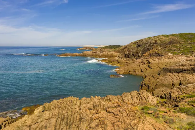 Aerial view of the brown Rocks and blue water of the Tasman Sea at Birubi Point near Port Stephens in regional New South Wales in Australia