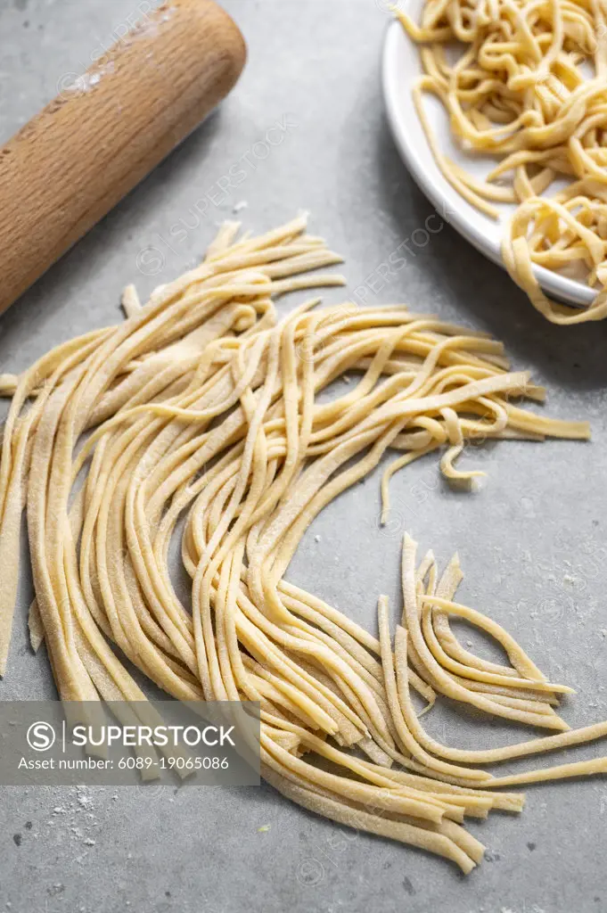 Raw homemade noodles, egg noodles. Home, healthy cooking concept.