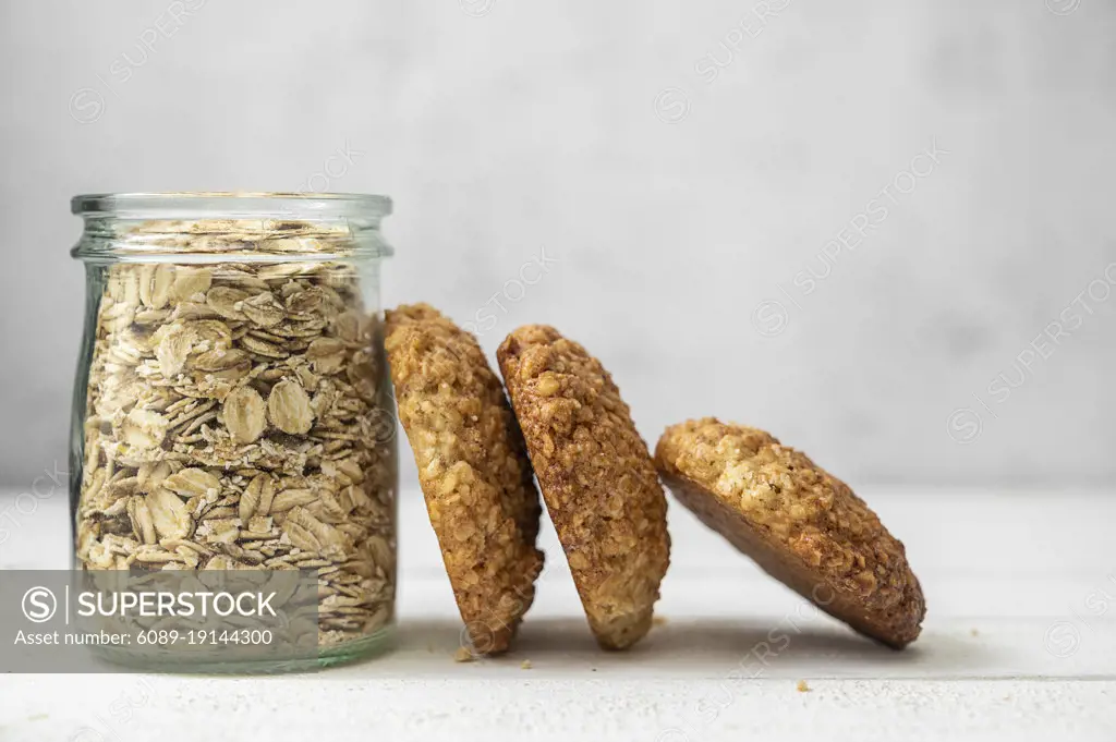 Oat cookies, healthy sweet homemade dessert and a jar with oats over bright background