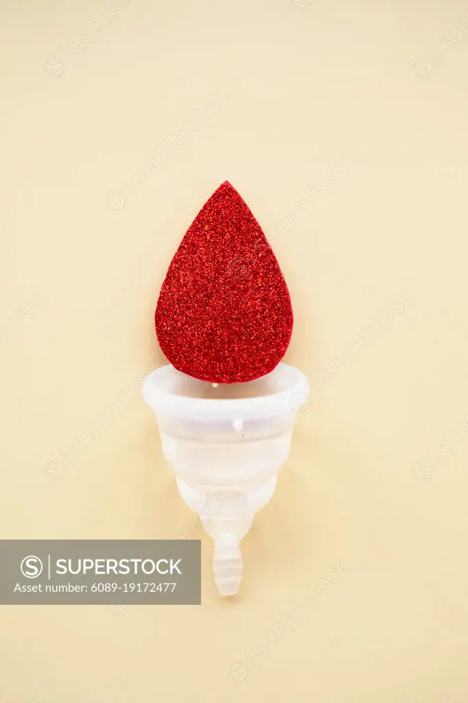 Menstrual cup with blood drop, abstract woman's health concept