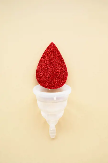Menstrual cup with blood drop, abstract woman's health concept