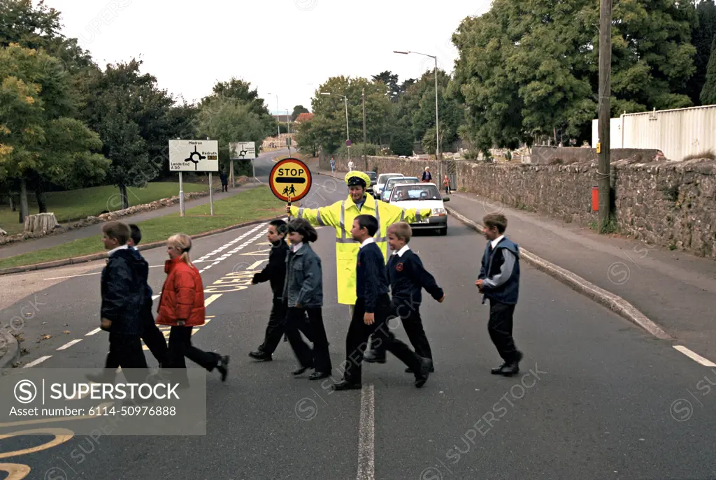 Lollipop lady on duty at school crossing patrol. She has stopped traffic to allow the schoolchildren to cross the road in safety. This image may only be used to portray the subject in a positive manner.©shoutpictures.comjohn@shoutpictures.com