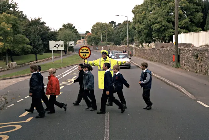 Lollipop lady on duty at school crossing patrol. She has stopped traffic to allow the schoolchildren to cross the road in safety. This image may only be used to portray the subject in a positive manner.©shoutpictures.comjohn@shoutpictures.com