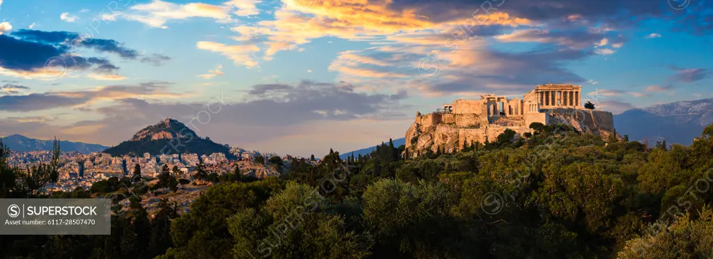 Panorama of famous greek tourist landmark - the iconic Parthenon Temple at the Acropolis of Athens as seen from Philopappos Hill on sunset. Athens, Greece