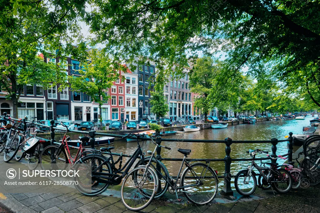 Typical Amsterdam view - Amsterdam canal with boats and bicycles on a bridge. Amsterdam, Netherlands