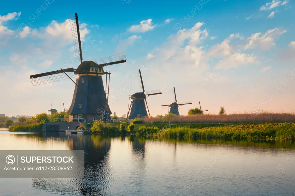 Netherlands rural landscape with windmills at famous tourist site Kinderdijk in Holland on sunset with dramatic sky