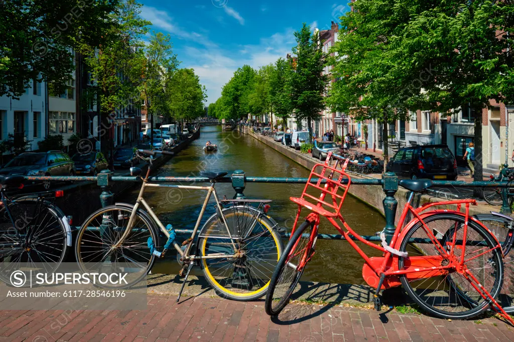 Typical Amsterdam view - Amsterdam canal with boats and bicycles on a bridge. Amsterdam, Netherlands