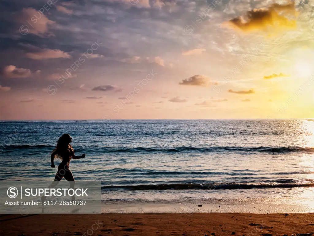 Healthy sporty fitness fit life concept - beautiful athletic woman running along sea on the beach in the morning