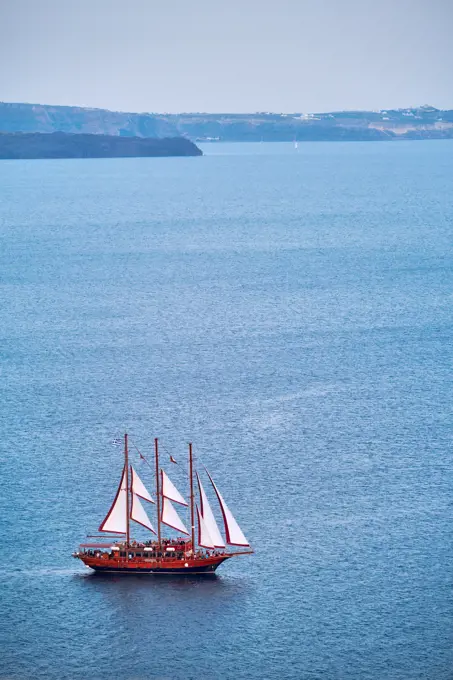 Tourist schooner vessel ship boat in Aegean sea near Santorini island with tourists going to sunset viewpoint. Santorini, Greece