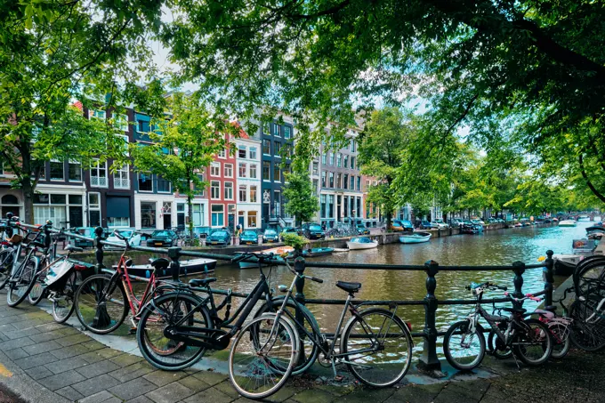 Typical Amsterdam view - Amsterdam canal with boats and bicycles on a bridge. Amsterdam, Netherlands