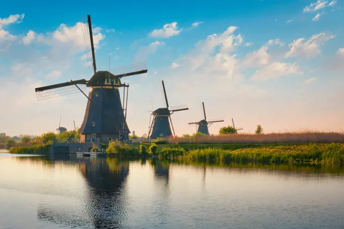 Netherlands rural landscape with windmills at famous tourist site Kinderdijk in Holland on sunset with dramatic sky