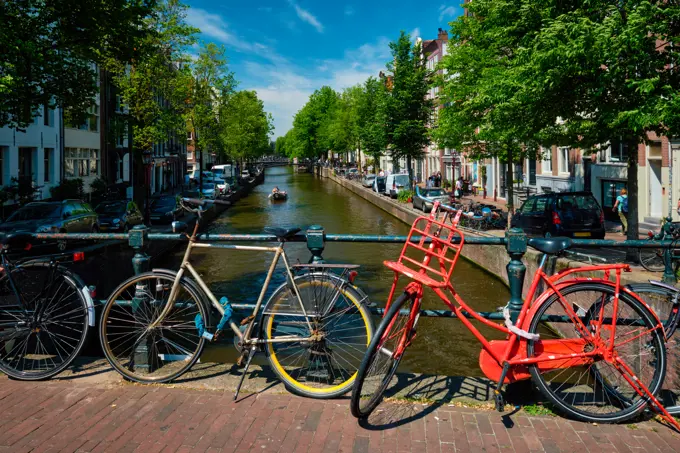 Typical Amsterdam view - Amsterdam canal with boats and bicycles on a bridge. Amsterdam, Netherlands