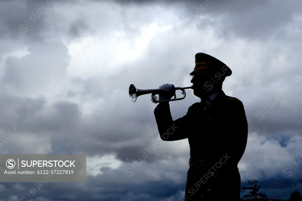 Silhouette of a man playing taps on his bugle at a veterans funeral at Medical Lake Veterans Memorial in Washington.