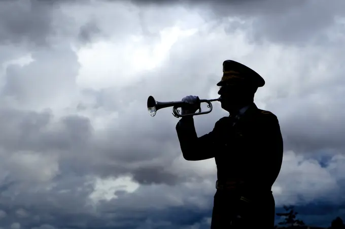 Silhouette of a man playing taps on his bugle at a veterans funeral at Medical Lake Veterans Memorial in Washington.