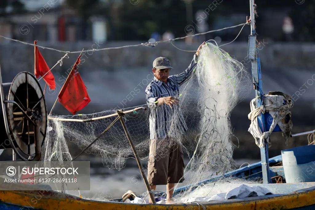 Fisherman repairing fishing nets. Hang Dua bay. Vung Tau. Vietnam. -  SuperStock