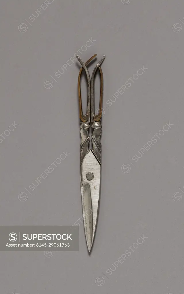 Scissors, c. 1770. England, 18th century. Luxurious personal objects were an essential part of a privileged wardrobe during the 1700s and early 1800s, emphasizing their owners refinement and wealth. Especially popular were étuis, small ornamented cases containing miniature sewing, writing, or grooming implements that hung at a womans waist from an ornate clasp, known as a chatelaine. Despite its glittering surface, this small expensive set disguised a system based on the labor and suffering of enslaved or indentured people, whether in gold and stone mines or the shop where it was made.