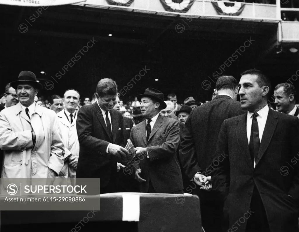 Opening Day at D.C. Stadium, 1962 Baseball Season, 2:00PM. President John F. Kennedy talks with General Elwood Pete Quesada, majority owner of the Washington Senators, during the opening game of the 1962 baseball season. Those pictured include: Special Assistant to the President Lawrence Larry O'Brien; Special Assistant to the President Dave Powers; Special Assistant to the President Timothy Reardon; Senator Mike Mansfield of Montana; Representative Charles Halleck of Indiana; Secret Service Agent John Muggsy O'Leary; Secretary of the Interior Stewart Udall; Senator George Smathers of Florida. D.C. Stadium, Washington, D.C.