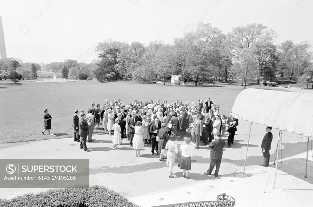 Visit of members of the Knights of Columbus, Charlestown, Massachusetts. President John F. Kennedy (in crowd, center background) visits with members of the Bunker Hill Council of the Knights of Columbus from Charlestown, Massachusetts. Also pictured: Special Assistants to President Kennedy, Dave Powers and John J. McNally; White House Communications Agency (WHCA) officer, Joseph W. Culbreth; and White House Secret Service agents, Ernie Olsson and Sam Sulliman. South Lawn driveway in front of the South Portico, White House, Washington, D.C.