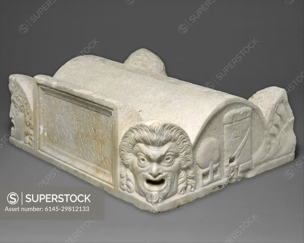 Marble lid of a cinerary chest late 1st century A.D. Roman The lid is fashioned to look like the roof of a barrel-vaulted building with acroteria at the corners in the form of theatrical masks and palmettes. The front panel is inscribed in Latin: To the spirits of the dead, [of Sextus Flavius Pancarpus, who lived 67 years.” Despite the fact that the inscription mentions only a man, the lunettes at the sides show both male (globe and box of scrolls) and female (mirror and spindle) attributes, indicating that the chest also may have contained the remains of Pancarpus’ wife.. Marble lid of a cinerary chest 256583