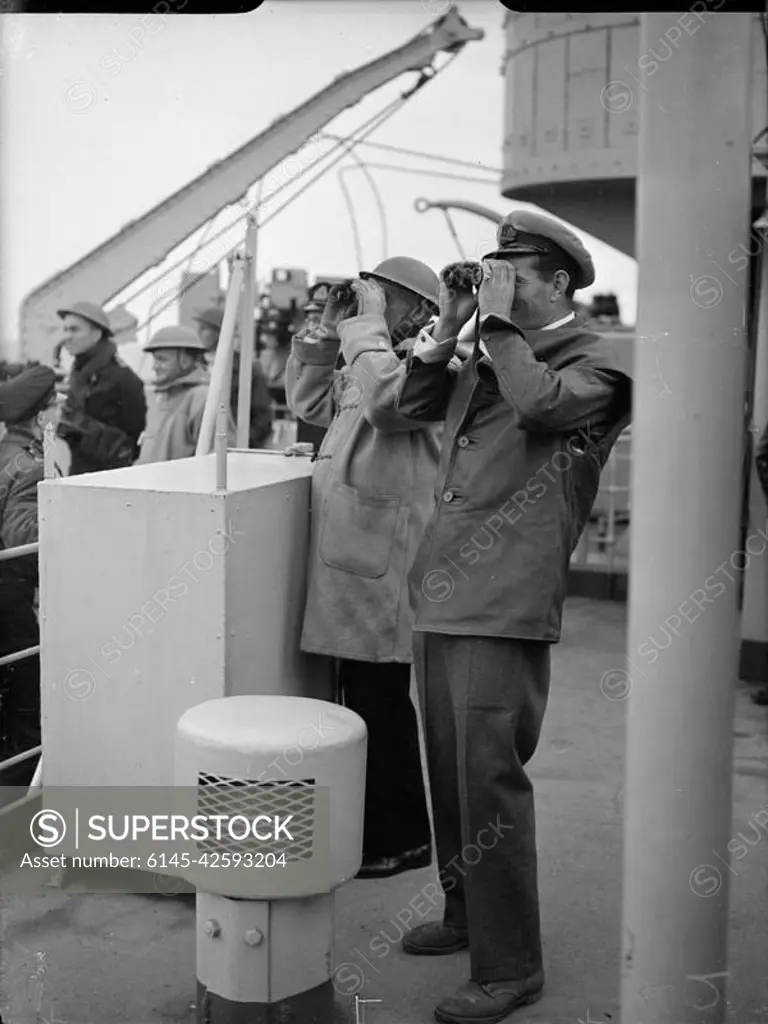 D-day - British Forces during the Invasion of Normandy 6 June 1944 Captain Sir Harold Campbell RN and Commander A Kimmins RN watch the progress of the landing of 50th Division from HMS BULOLO, headquarters ship of Assault Force G, 6 June 1944.