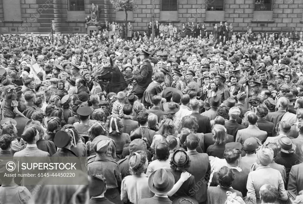 Ve Day Celebrations in London, England, UK, 8 May 1945 A mounted policeman moves through crowds of people gathered in Whitehall, London, to hear Churchill's Victory speech and to celebrate Victory in Europe Day, 8 May 1945.