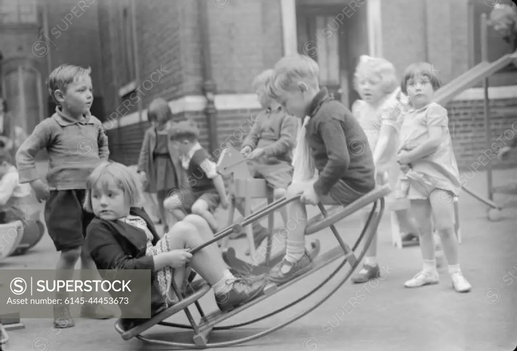 Boys Lessons Provide Wartime Toys, London, England, UK, 1943 In the playground of an infant school in north London, young children play on the new see-saw made for them by the boys of Medburn Road School from salvaged materials.