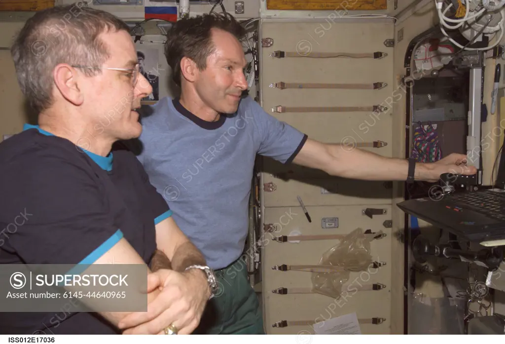 ISS012-E-17036 (23 Jan. 2006) --- Astronaut William S. (Bill) McArthur (foreground), Expedition 12 commander and NASA space station science officer, and cosmonaut Valery I. Tokarev, flight engineer representing Russia's Federal Space Agency, watch the contents of a compact disk at a work station in the Zvezda Service Module of the International Space Station. The compact disk was in the Radioskaf (SuitSat) package delivered to the station by a Progress spacecraft.