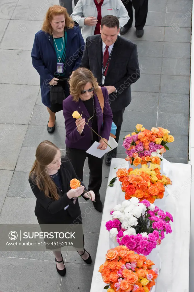 Following this year's Day of Remembrance ceremony at the Kennedy Space Center Visitor Complex, guests pick up flowers to place at the Space Mirror Memorial. The names of fallen astronauts from Apollo 1, Challenger and Columbia, as well as the astronauts who perished in training and commercial airplane accidents are emblazoned on the monument. Each year spaceport employees and guests join others throughout NASA honoring the contributions of astronauts who have perished in the conquest of space.