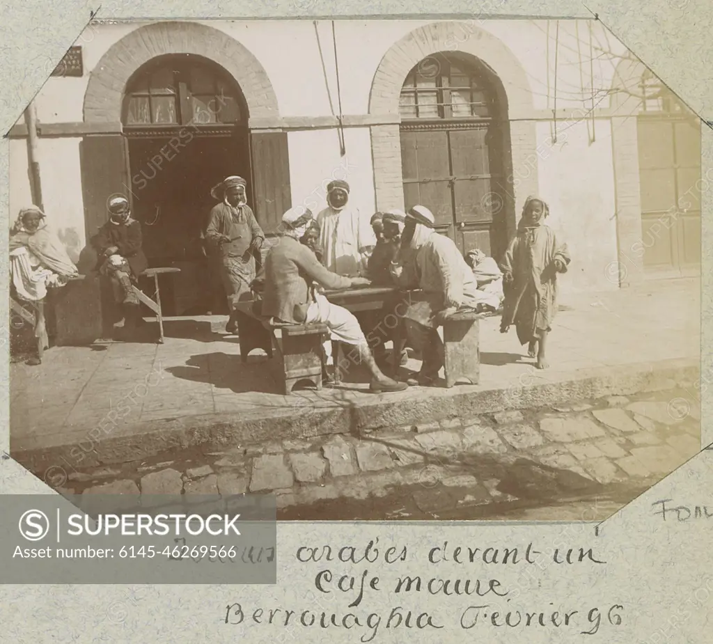 Men during a board game for a cafe in Berrouaghia (Algeria). Part of a  French amateur album with photos of France, Algeria, Palmyra, the 1900  World Exhibition and of Famous Fransen. - SuperStock