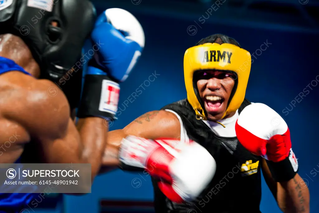 LACKLAND AIR FORCE BASE, Texas-- Spc. Zacchaeus Hardrick (right), a boxer representing the U.S. Army team, punches Air Force Staff Sgt. Gary Griffin (left), during their bout at the 2011 Armed Forces Boxing Championship at the Chaparral Fitness Center, Feb. 15, 2011. The AFBC is an elite competition between military service branches. Winning a gold medal in the event qualifies the athlete to compete in the 2012 Olympic team trials.